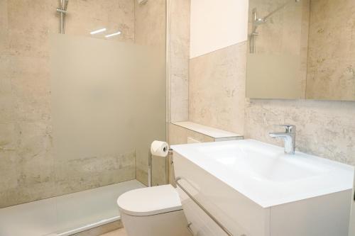 a white bathroom with a sink and a toilet at Ferienwohnung Seeland in Niendorf