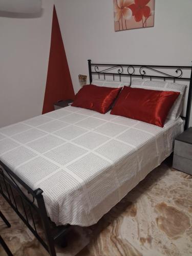 a bed with red pillows on it in a room at Bracchi's room franciacorta in Cazzago San Martino