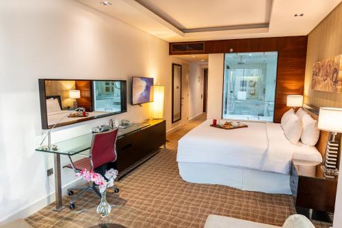 a hotel room with a bed and a desk at Majestic Premier Hotel Burdubai in Dubai
