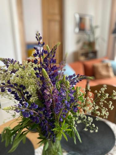 a vase filled with purple flowers on a table at SecondHomeViljandi Apartment in Viljandi