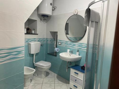 a bathroom with a sink and a toilet and a mirror at Giovanna dei Rocca - appartamento sul mare in Riomaggiore