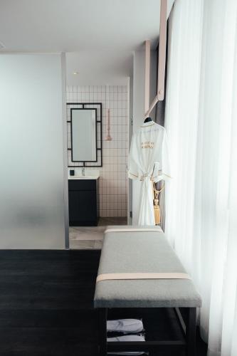 a bathroom with a bench and a sink and a mirror at SOOKNIRUND HOTEL in Chiang Rai