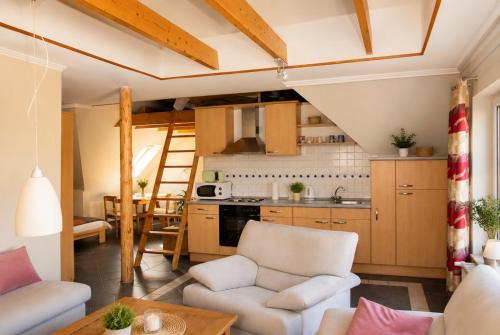 a kitchen and living room with white furniture and wooden cabinets at Fehn Appartement II - Stay Apartment nahe Zentrum, Küche, Parkplatz & Highspeed WLAN in Papenburg