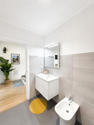 a white bathroom with a sink and a mirror at Villa Bavaria B in Ponta do Sol