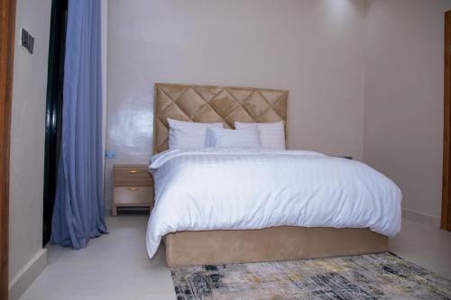 a bedroom with a large bed with white sheets and pillows at Dream Nest in Benin City