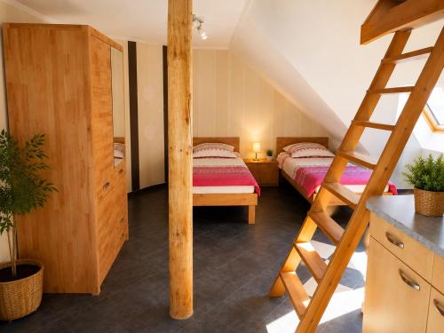 a bedroom with two beds and a ladder at Fehn Appartement II - Stay Apartment nahe Zentrum, Küche, Parkplatz & Highspeed WLAN in Papenburg