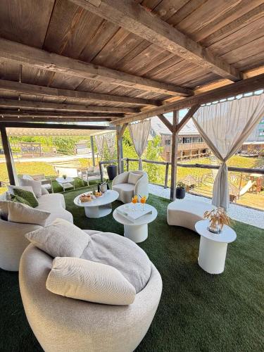 a living room with white couches and tables at Plitvice Lakes Hotel Ethno Houses in Plitvička Jezera