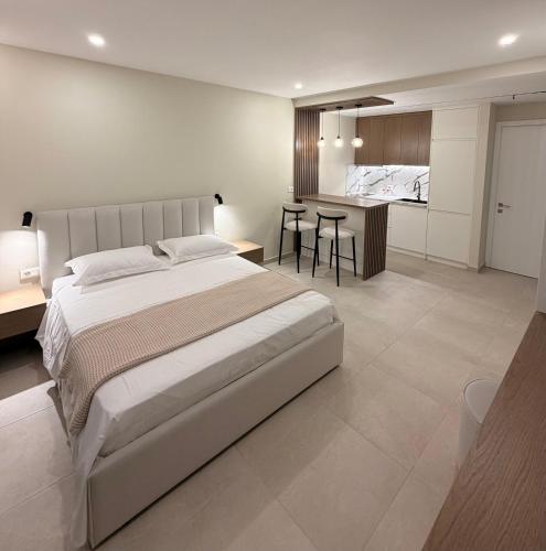 a bedroom with a large bed and a kitchen at Oasis in Vlorë