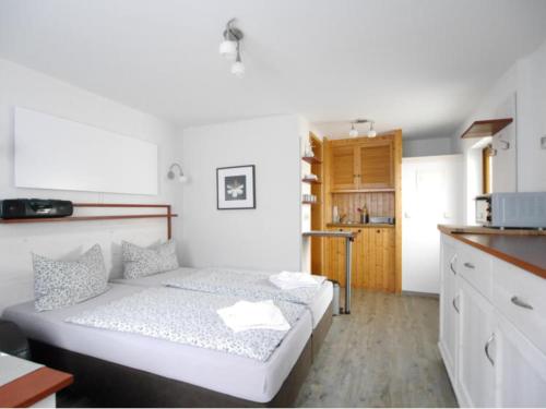 a small bedroom with a bed and a kitchen at Bungalow in Bansin