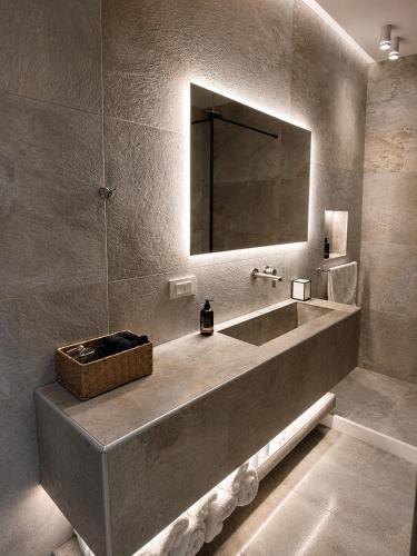 a bathroom with a large sink and a mirror at MykoNest in Agios Stefanos