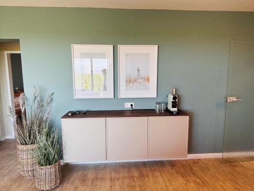 a bathroom with a sink and two pictures on the wall at Haus Nige Wark - Ferienwohnungen in Cuxhaven
