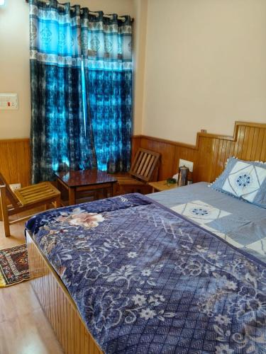a bedroom with a bed with a blue blanket on it at Apple Zone Home stay in Banjār