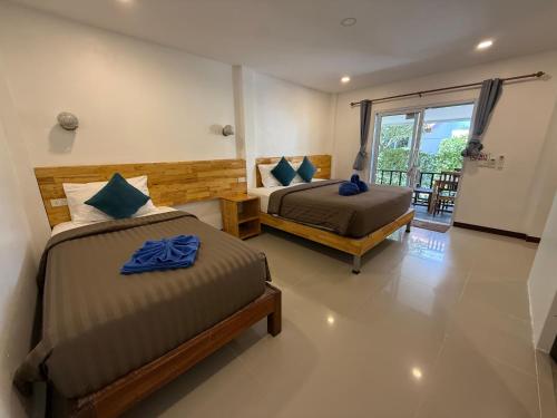 a bedroom with two beds and a balcony at CheeVa Beach Resort in Ban Tai