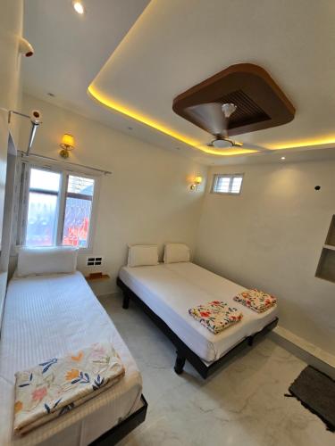 a bedroom with two beds and a ceiling at TEMPLE VIEW GUEST HOUSE in Hampi