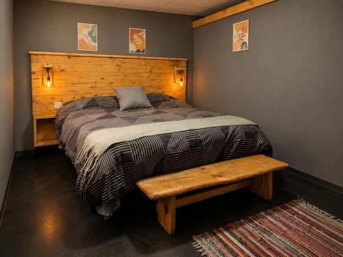 a bedroom with a bed with a wooden headboard and a bench at Tierras Mágicas in Villa Pehuenia