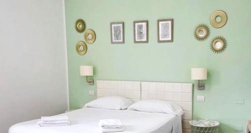 a bedroom with two beds with white sheets and mirrors at Le Suite dei Due Mari cucinino privato in Taranto
