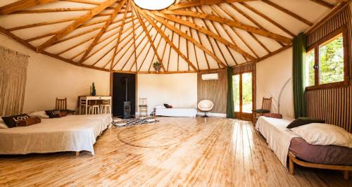 a large room with two beds and a wooden floor at DES BRANCHES & VOUS in Châteauneuf-sur-Isère