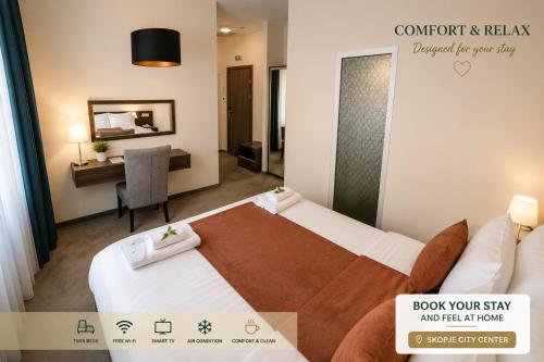 a hotel room with two beds and a desk at Hotel Cara 28 in Skopje