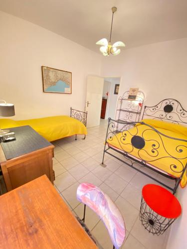 a bedroom with two beds and a table and chairs at Casa Rosso Melograno in Alassio