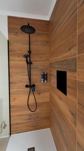 a shower in a room with wood paneling at Francisca Apartment in Lajes