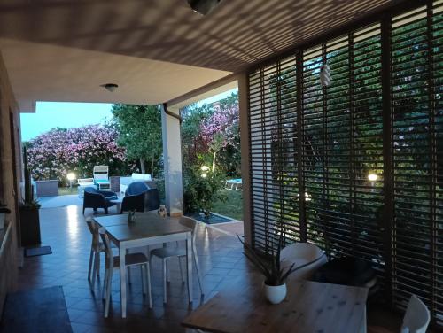 a patio with a table and chairs and windows at La Principessa Nera B&B in Ostra