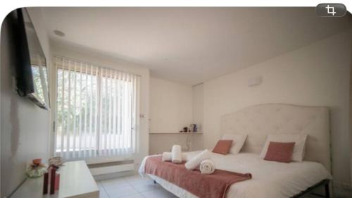 a bedroom with a large bed and a large window at Maison orchidée in Nîmes