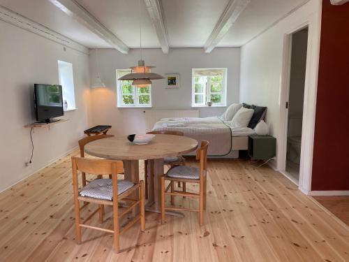 a room with a table and a bed and a bedroom at Davinde Gæstgiveri in Odense