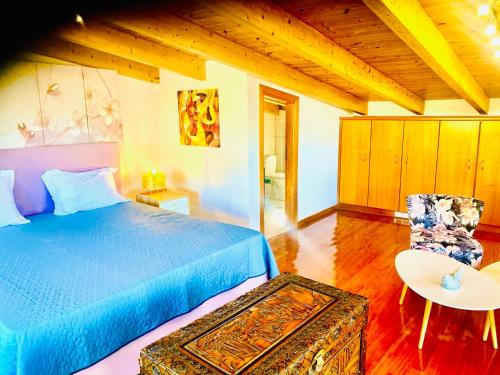 a bedroom with a blue bed and a table and a chair at Asclepeias Ionian Villa in Argassi