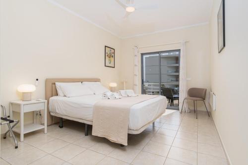 a bedroom with a large white bed and a table at Ria Olhao in Olhão