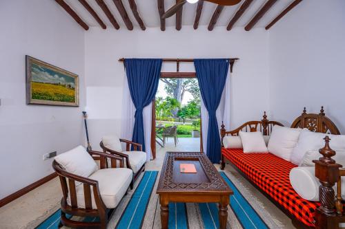 a living room with a couch and a table at Kasa Pomboo Hotel, Shimoni in Shimoni