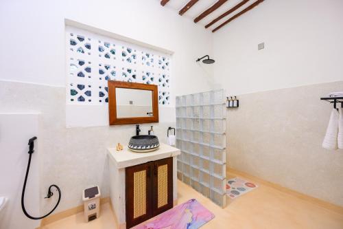 a bathroom with a sink and a mirror on the wall at Kasa Pomboo Hotel, Shimoni in Shimoni