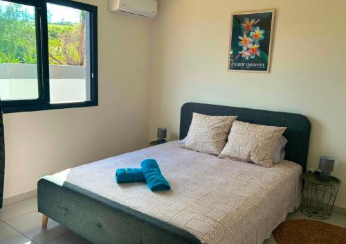a bed with two blue pillows on it in a bedroom at La Villa Bleu Lagon in Petite Île