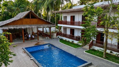 a resort with a swimming pool in front of a building at Jungle Vibes Hostel in San Juan