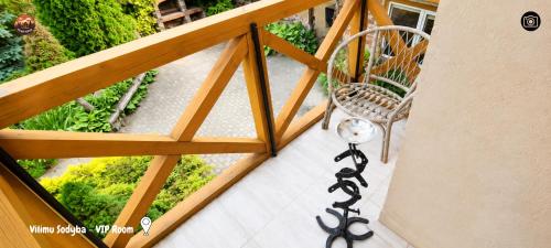 a balcony with a chair and a clock on the floor at Vilimu Sodyba - VIP Room in Kriukai