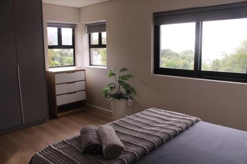 a bedroom with a bed with towels on it at Simons Town long beach Penthouse in Simonʼs Town