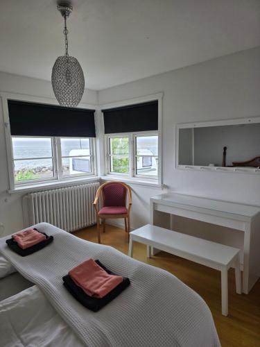 a bedroom with two beds and a desk and a chair at Kríukot íbúð in Hólmavík