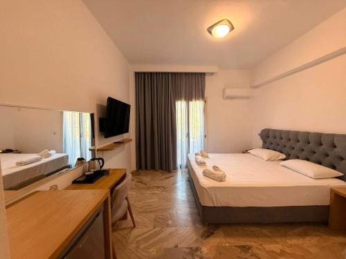 a hotel room with two beds and a television at Lili Hotel in Amoudara Herakliou