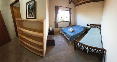 a room with a bed and a staircase with a window at Chalé Jardim Mágico in Milho Verde