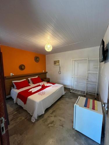 a bedroom with a large bed with red pillows at Pousada In Paradiso in Santa Cruz