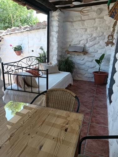 a patio with a bed and a table and chairs at Casas Amaro in Órgiva