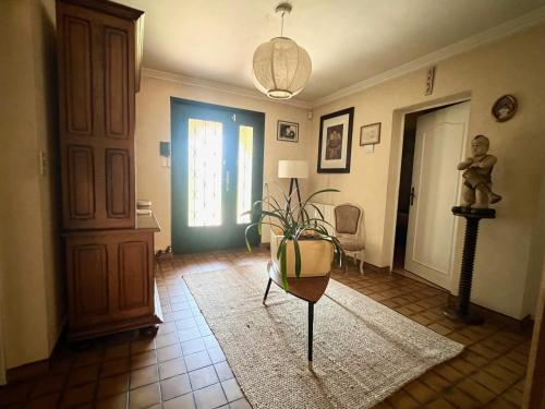 a living room with a potted plant on a floor at Maison familiale in Paulhac
