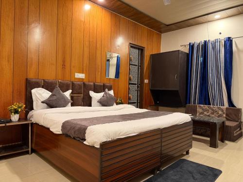 a bedroom with a large bed and a flat screen tv at HOTEL The Puadh Stay in Lāndrān