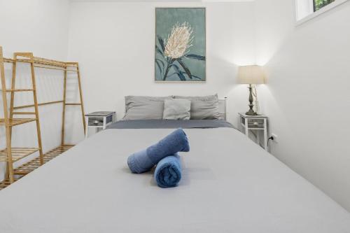 a bedroom with a bed with a blue towel on it at Lovely Hidden Gem in Redcliffe in Redcliffe