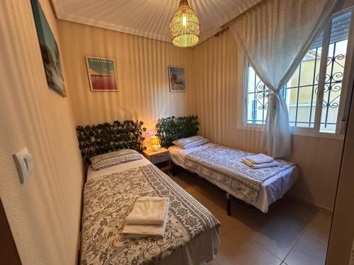 a bedroom with two beds and a window at Altos Bahia Magic in Torrevieja