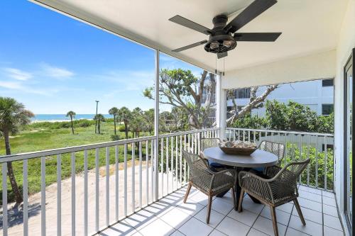 a balcony with a table and chairs and a ceiling fan at South Seas Beach Villa 2428 in Captiva