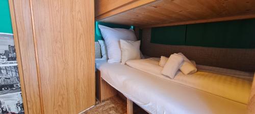 a small room with a bed with white pillows at Tiny Anna's Cozy Home near Redbull Ring in Liesingthal