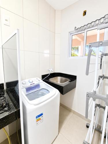 a white bathroom with a sink and a washing machine at Brisa do Preá- 700m da Praia do Preá -12km de Jeri in Prea