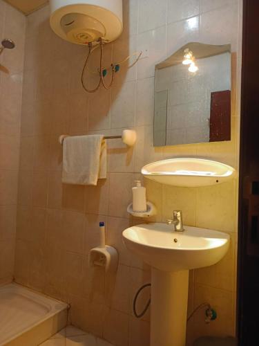 a bathroom with a sink and a mirror and a tub at فندق سكب الأصيل in An Naqāʼ