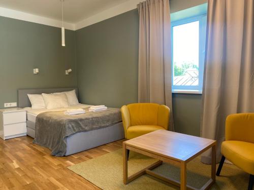 a bedroom with a bed and two chairs and a table at "Pas draugą" Šalkauskio g in Kaunas