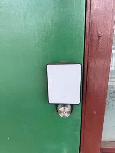 a door with a white box on a green wall at Roxy inn in Oita